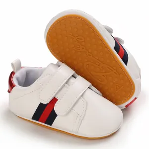 Detail of white leather baby pre-walker shoes featuring a non-slip soft rubber sole.