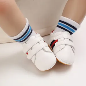Close-up of white baby walker shoes with non-slip soft rubber soles for infant boys