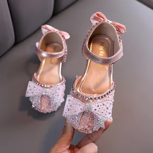 Elegant pink girls princess dress shoes featuring sparkling rhinestone bow and satin ribbon
