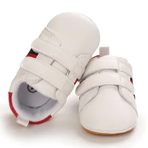 Front view of white baby walking shoes with velcro straps and soft non-slip sole