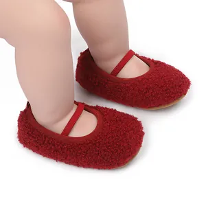 Close-up macro view of red fuzzy Sherpa baby walking shoes with elastic strap detail