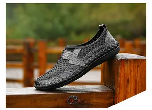 Close-up view of black breathable mesh slip-on shoes featuring crocodile texture detail