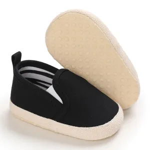 Classic black soft-sole infant pre-walker shoes featuring non-slip dots on beige sole