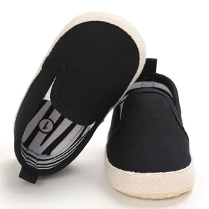 Close-up detail of black canvas baby slip-on walking shoes with a soft white sole