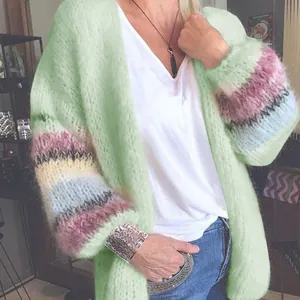 Gedetailleerde opname van een pluizig mintgroen mohair vest met kleurrijke gestreepte mouwen