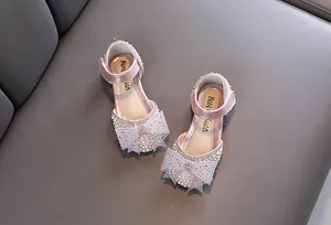 Close-up detail of pink glittery girls princess shoes with pearl and bow accents