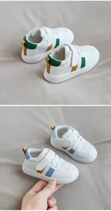 Detail view of toddler leather sneakers with Velcro straps in white and blue or green.