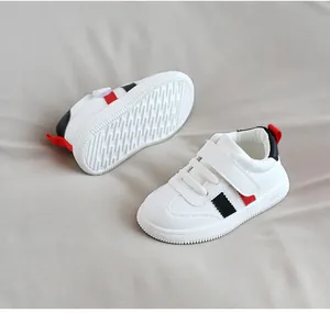 Close-up detail of toddler white leather walking shoes featuring a soft sole and velcro strap