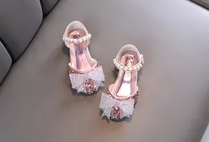 Detailansicht rosa Mädchen-Prinzessinenschuhe mit Strass-Schleife und Perlenriemen-Details.