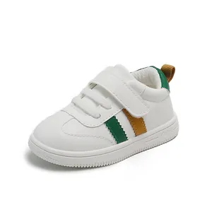 White toddler leather sneakers with green and yellow stripes and velcro strap