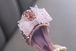 Detailaufnahme eines rosa Prinzessinnenschuhs für Mädchen mit einer Strassschleife