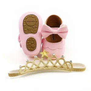 Detailed view of pink baby princess shoes with bow and gold glitter crown headband set.