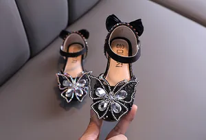 Close-up of black girl's princess shoes featuring a luxury rhinestone butterfly decoration