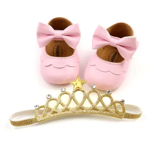 Detail view of pink baby princess shoes with bow and gold glitter crown headband set