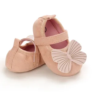 Detailed view of soft pink baby princess shoes with a large textured butterfly ornament