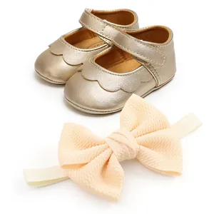 Detail view of gold PU baby walking shoes and matching cream bow headband set