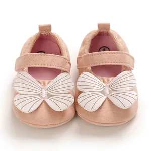 Close-up of pink baby princess shoes with large decorative butterfly and soft suede texture