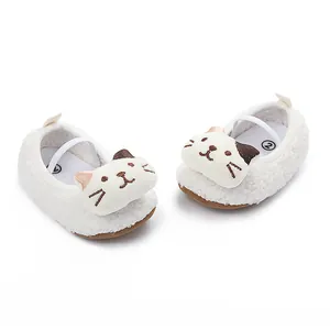 Close-up of white plush baby walking shoes with cute cartoon cat face