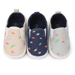 Detailopname van baby slip-on schoenen met levendige dinosauruspatronen op canvas.