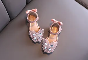 Close-up of pink girls' princess sandals featuring sparkling rhinestone butterfly details