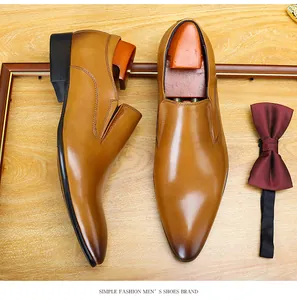 Detailed top-down view of tan leather slip-on shoes with burgundy bow tie decoration
