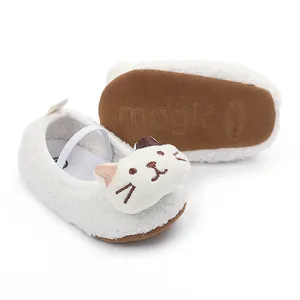 Macro view of white fuzzy baby pre-walker shoes featuring a cute cartoon cat face.