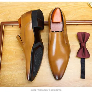 Top-down view of tan pointed-toe business leather shoes with premium accessories.