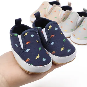 Detailed macro shot of navy baby pre-walker shoes featuring a colorful dinosaur print pattern