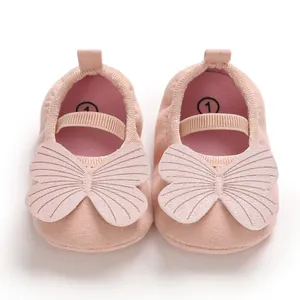 Close-up detail of pink baby girl walking shoes with large butterfly decorative design