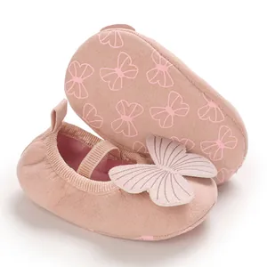 Detail view of pink infant walker shoes featuring soft non-slip soles and butterfly charm