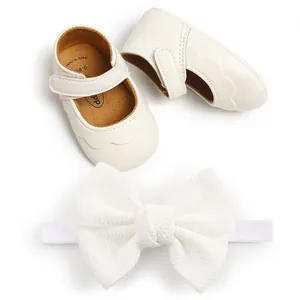 Close-up of white PU leather baby princess shoes with matching bow headband detail