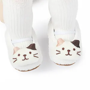Detailed macro view of white sherpa baby toddler shoes featuring a cute embroidered cat face design