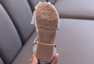 Close-up of non-slip rubber sole with star pattern for girls' rhinestone sandals
