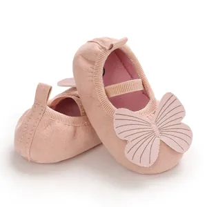 Close-up detail of soft-soled pink infant walking shoes featuring a large butterfly applique
