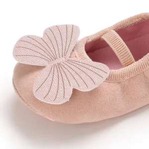 Detailed close-up of the butterfly decoration on a pink soft-soled baby girl shoe