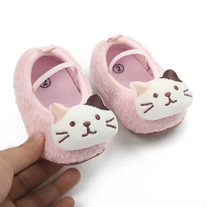 Detail of pink fuzzy baby pre-walker shoes with cute cartoon cat face decoration