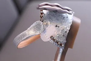 Close-up of sparkling rhinestone and bow details on silver girl's princess sandal