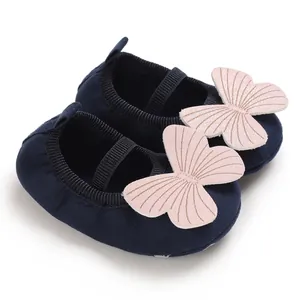 Detail view of navy baby girl walking shoes with soft sole and pink butterfly decoration