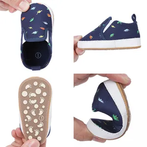 Gedetailleerde weergaven van baby dinosaur geprinte schoentjes met flexibele zool.