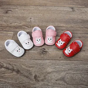 Detailansicht handgefertigter Babyschuhe mit niedlichem Cartoon-Katzen-Design und Klettverschluss