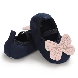 Detail view of navy baby girl walking shoes with a soft sole and pink butterfly applique