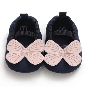 Close-up view of navy blue baby shoes with pink butterfly decoration and non-slip soft sole