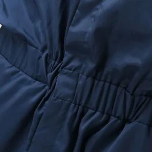 Detailed macro view of the elasticated waistband on a navy blue men's jumpsuit fabric.