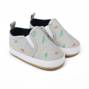 Detail van instapschoenen voor baby's met dinosauruspatronen en flexibele rubberen zolen.