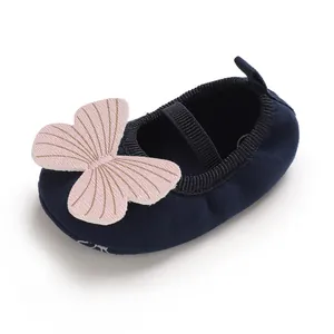 Close-up detail of navy blue baby girl walker shoe featuring a large pink butterfly applique
