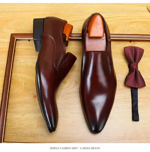 Top view of elegant burgundy men's slip-on leather shoes with matching bow tie accessory