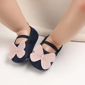 Detail view of navy blue baby walking shoes with pink butterfly and soft anti-slip soles.