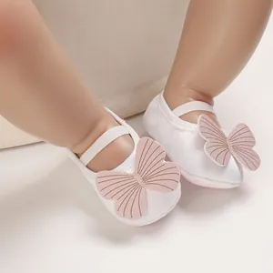 Detailed close-up of white baby girl walking shoes featuring a cute pink butterfly decor