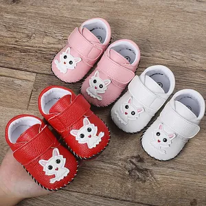 Detailansicht von rosa, weißen und roten Baby-Lernschuhen auf einem Holzhintergrund