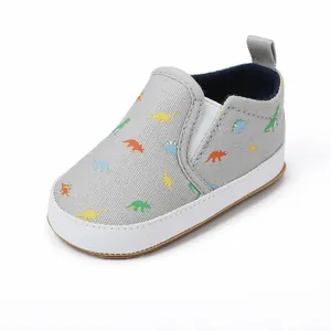 Detail van grijze baby canvas instapschoenen met kleurrijke dinosauruspatronen